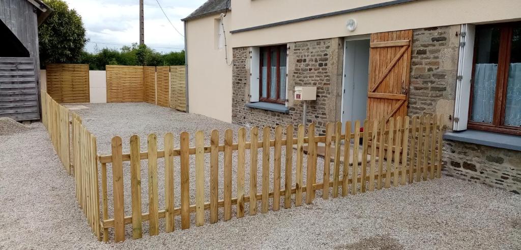 une clôture en bois devant une maison dans l'établissement La huberdiere, à Surville