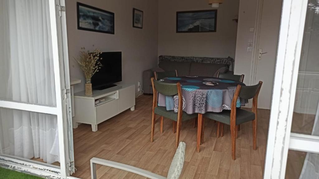 une salle à manger avec une table, des chaises et une télévision dans l'établissement Studio calme, à Carnac