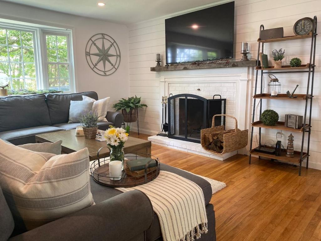 a living room with a couch and a fireplace at Walk2beach, Hottub, Firepit, Petsok in Dennis