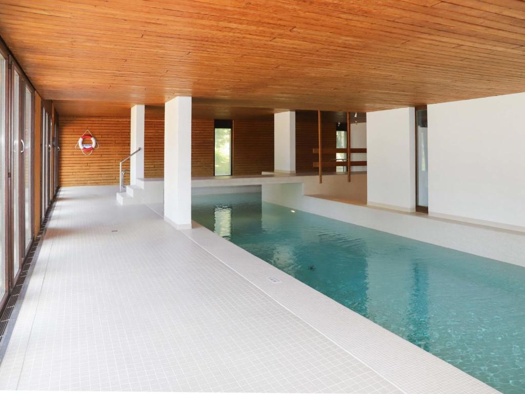 a swimming pool in a building with a wooden ceiling at Apartment Jeanne D'Arc Apt- C-28 by Interhome in Crans-Montana