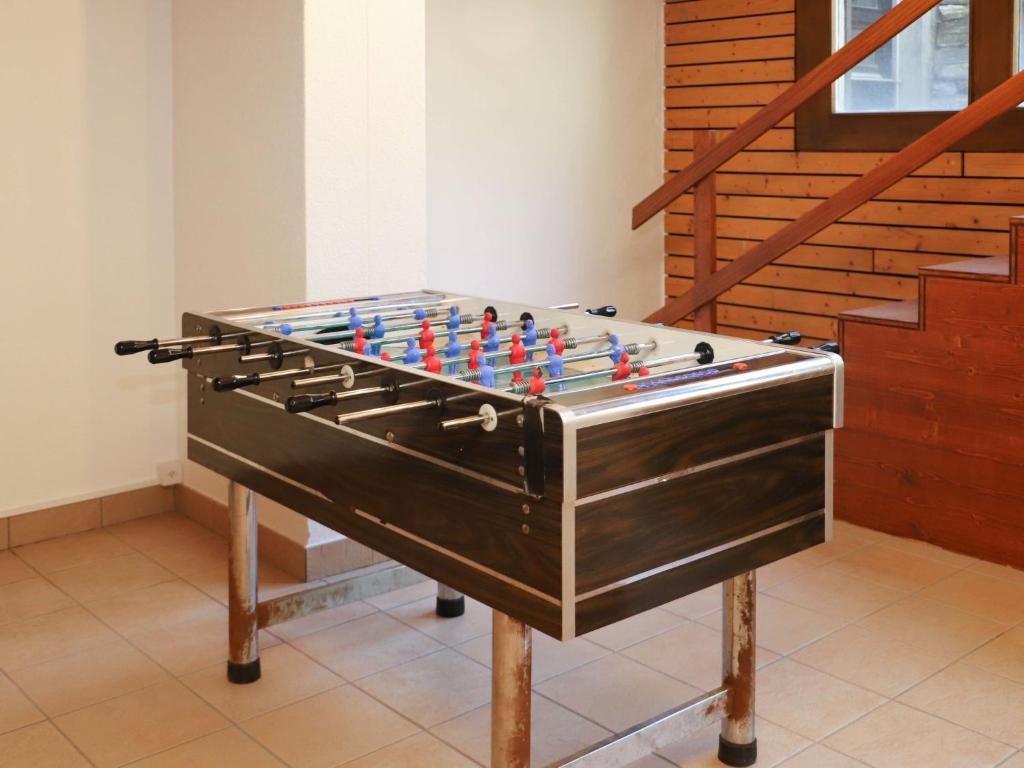 a foosball table in a room next to a staircase at Apartment Jeanne D'Arc Apt- C-28 by Interhome in Crans-Montana