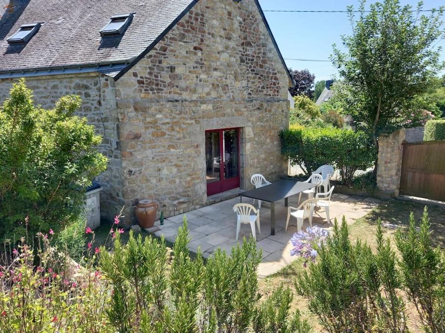 un patio avec une table et des chaises devant un bâtiment dans l'établissement Beau gîte 3 épis gîte de france, excellent emplacement de très belles plages , en bretagne sud, à Plouhinec