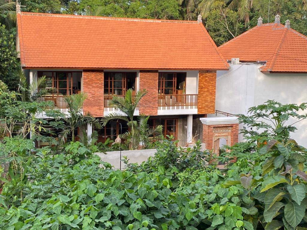a house with an orange roof in a garden at Ningmas Casita Residence Villa by Sidhi Experiences in Ubud