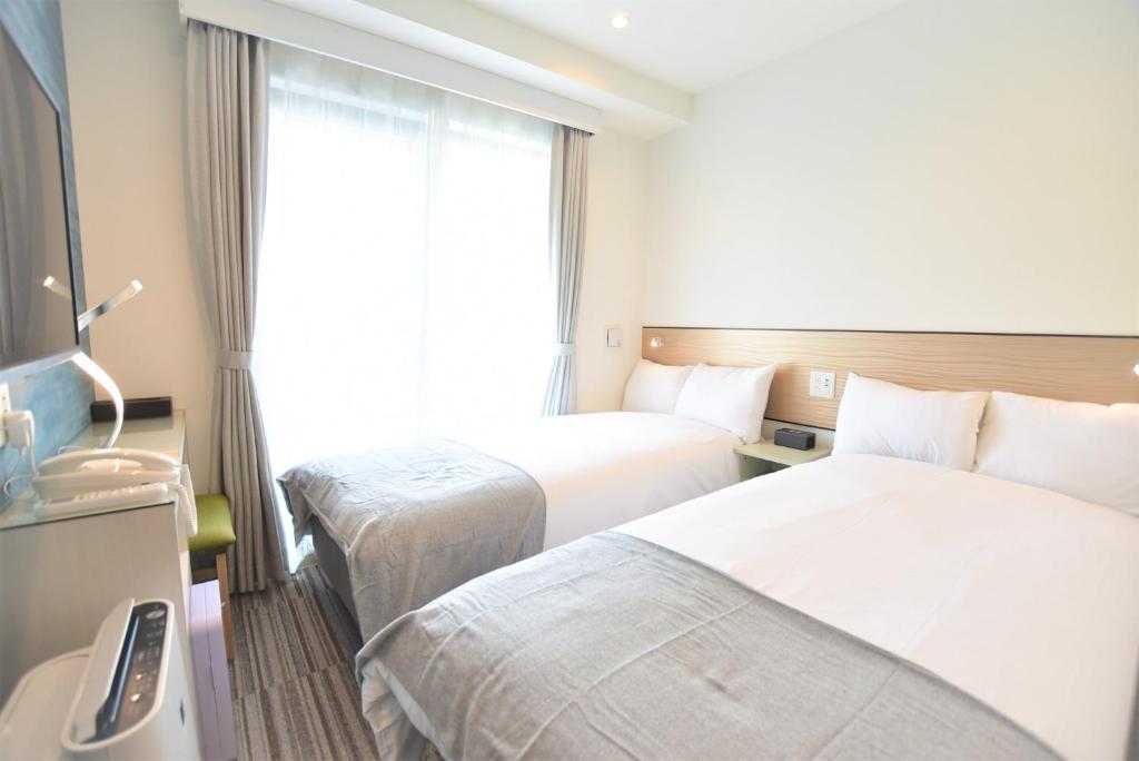Postel nebo postele na pokoji v ubytování ENKA NAMBA 1 HOTEL
