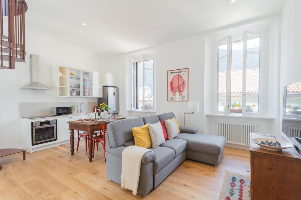 una sala de estar con un sofá y una mesa en Rooftop Nest in Como city center by Rent All Como, en Como