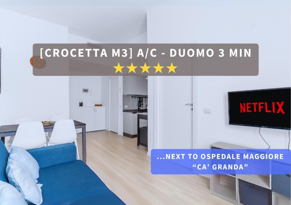 un soggiorno con un divano blu e una TV di Crocetta Charme Suite a Milano