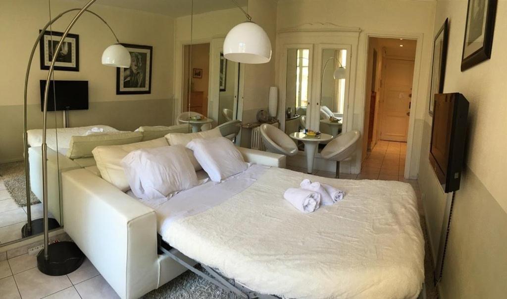 une chambre avec un lit blanc avec des serviettes dessus dans l'établissement Cannes Croisette - Studio au calme avec terrasse, à Cannes