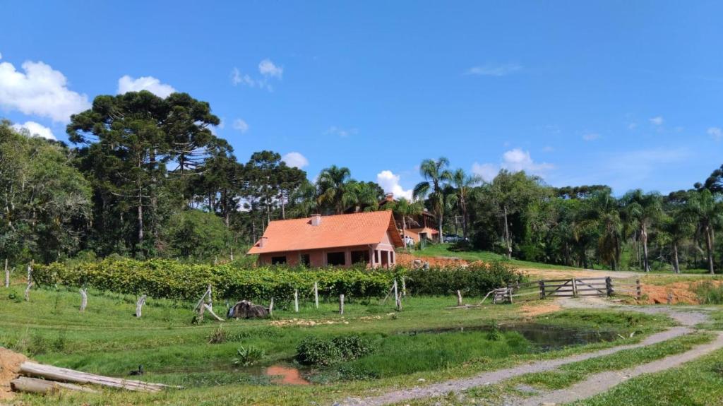 ein Haus inmitten eines Feldes mit einem Bauernhof in der Unterkunft Quarto Coralina - Bio Cult in Campo Alegre