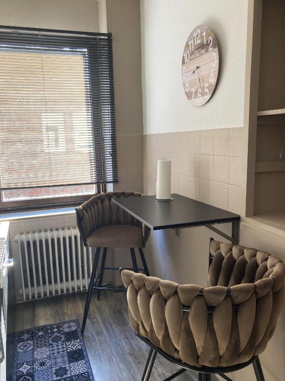 a dining room with a table and chairs and a clock at Time-Out Westerbauer TE13 in Hagen