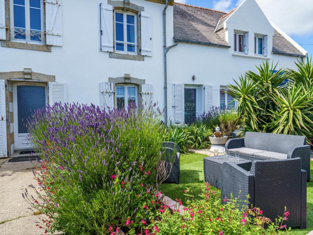 a garden in front of a house with flowers at Holiday Home la maison du bonheur by Interhome in Primelin