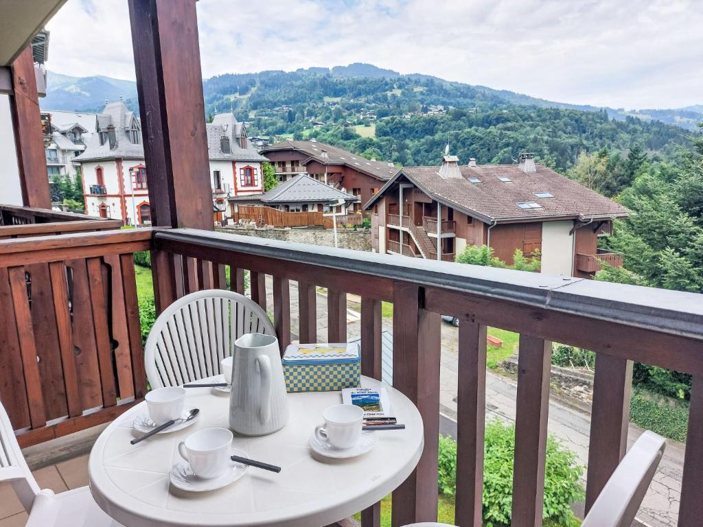 une table avec des tasses et des soucoupes sur un balcon dans l'établissement Apartment La Coupe de Cristal-7 by Interhome, à Saint-Gervais-les-Bains