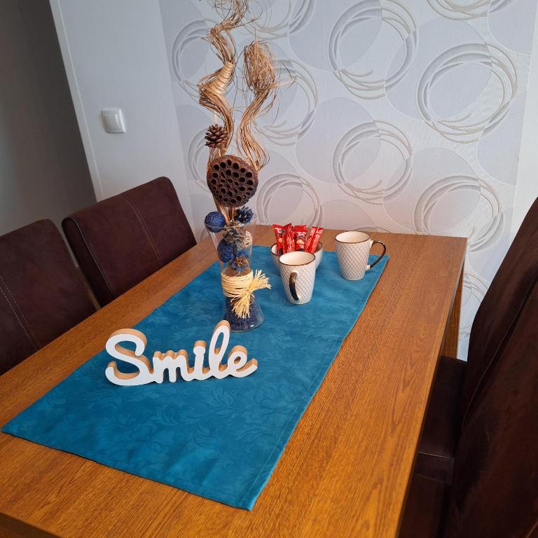 a table with a smile sign and two cups on it at Kraljevski kutak Kraljevi čardaci in Kopaonik