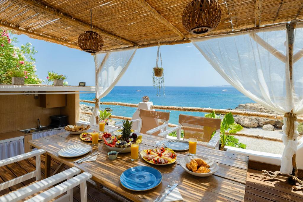 a dining table with a view of the ocean at Korali Sea House in Archangelos