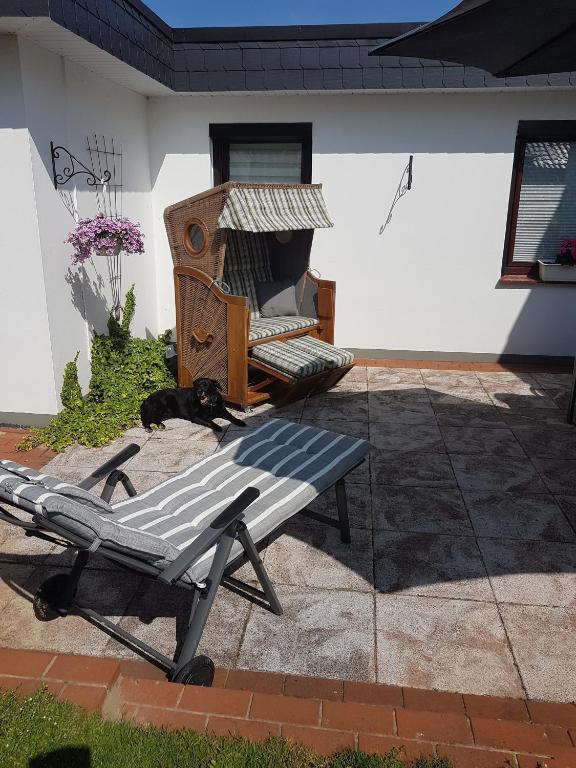 a dog laying on a patio next to a bench at Ferienhaus Leuchtturm in Geestland