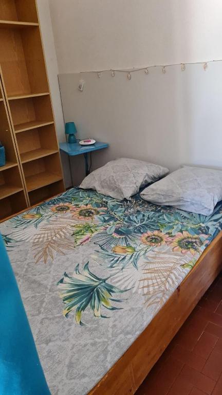 - un lit avec une couette colorée dans une chambre dans l'établissement appartement la méditerrannée port de gruissan, à Gruissan