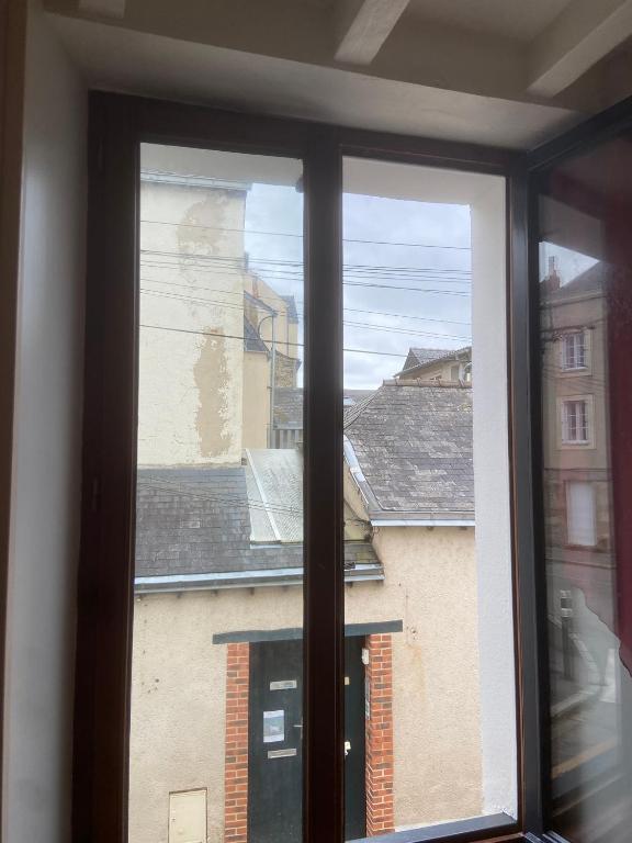 une fenêtre avec vue sur un bâtiment dans l'établissement Appartement Vacances, à Laval