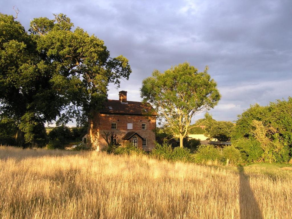 an old house in the middle of a field at Oak Tree Farm in Yoxford