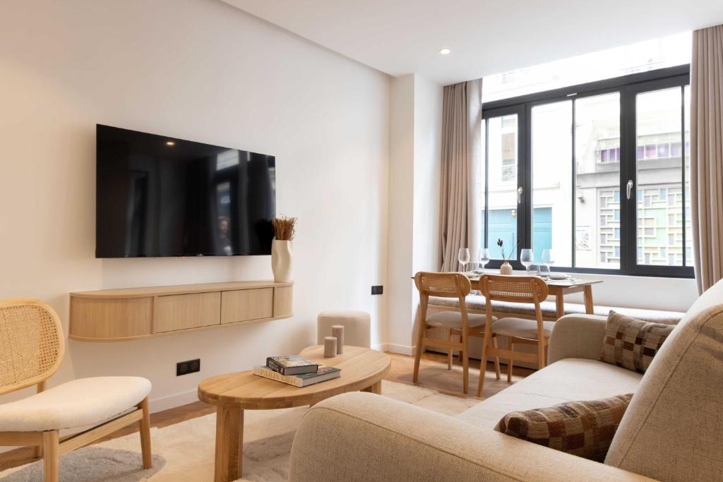 un salon avec une télévision et une salle à manger dans l'établissement Luxury residence - Port Royal - Rive Gauche, à Paris