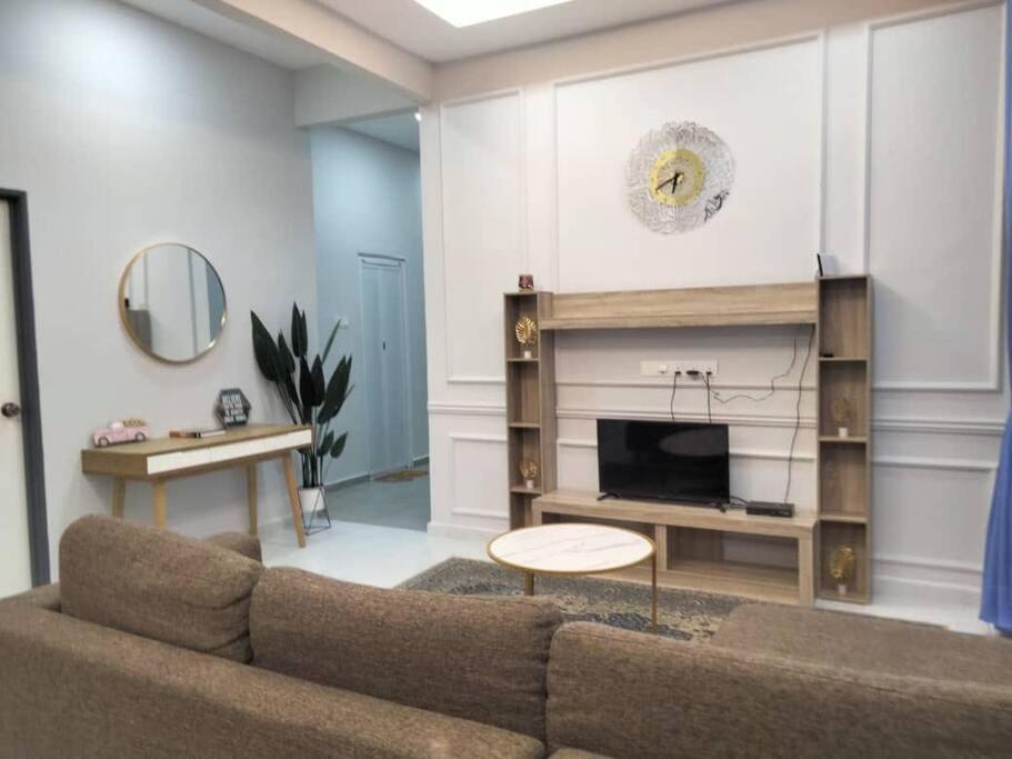 a living room with a couch and a fireplace at Ruls Homestay Kuala Nerus in Kampong Banggol Setol