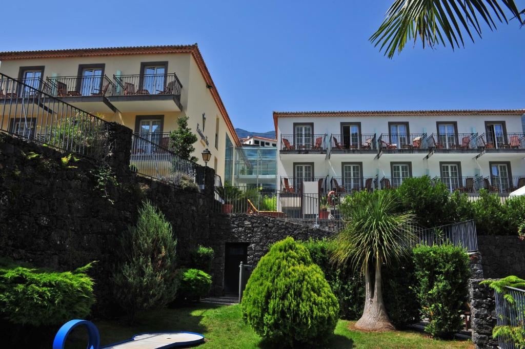 a building with a palm tree in front of it at Estalagem do Vale in São Vicente