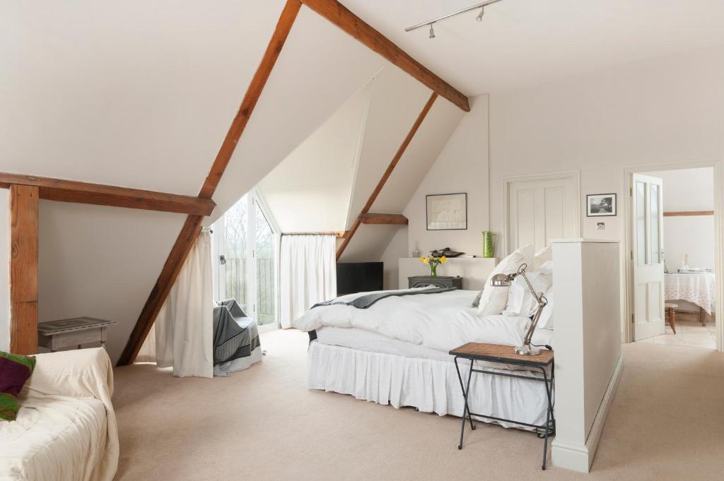 a white bedroom with a bed and a couch at The Clock Tower in Daventry