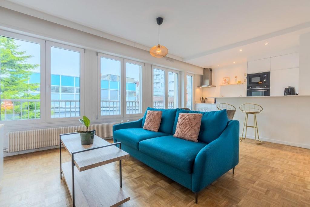 un salon avec un canapé bleu et une table dans l'établissement Attractive one-bedroom flat in the city centre, à Lille