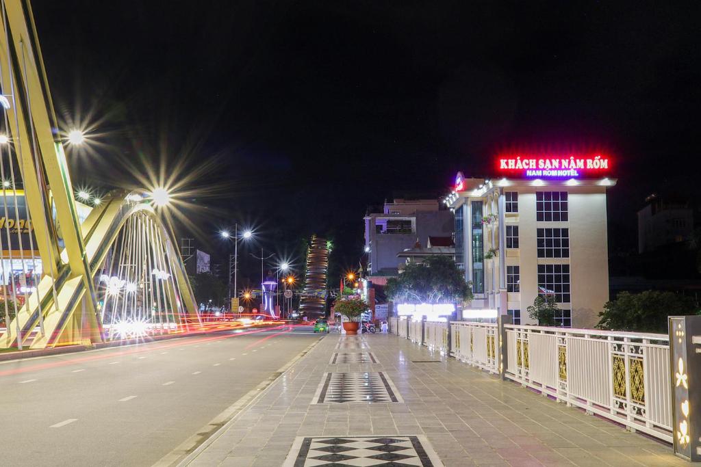 a city street at night with a bridge and buildings at Khách sạn Nậm Rốm in Diện Biên Phủ