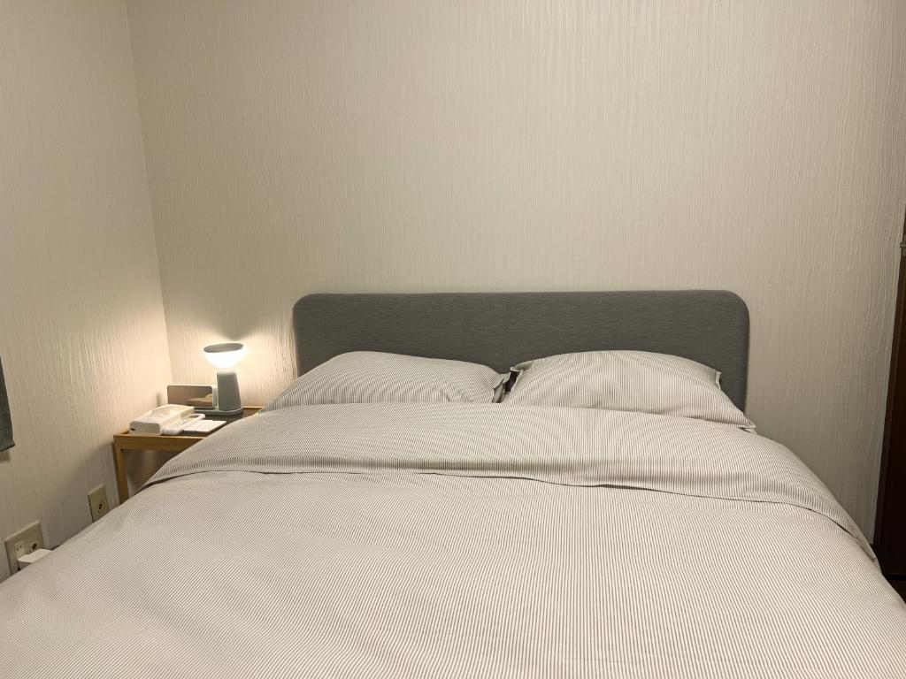 Postel nebo postele na pokoji v ubytování 嵐西成松