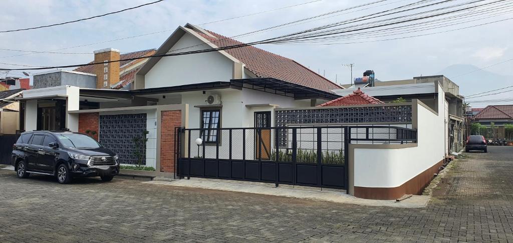 a black car parked in front of a house at RaYa GuestHouse & Pool in Purwokerto