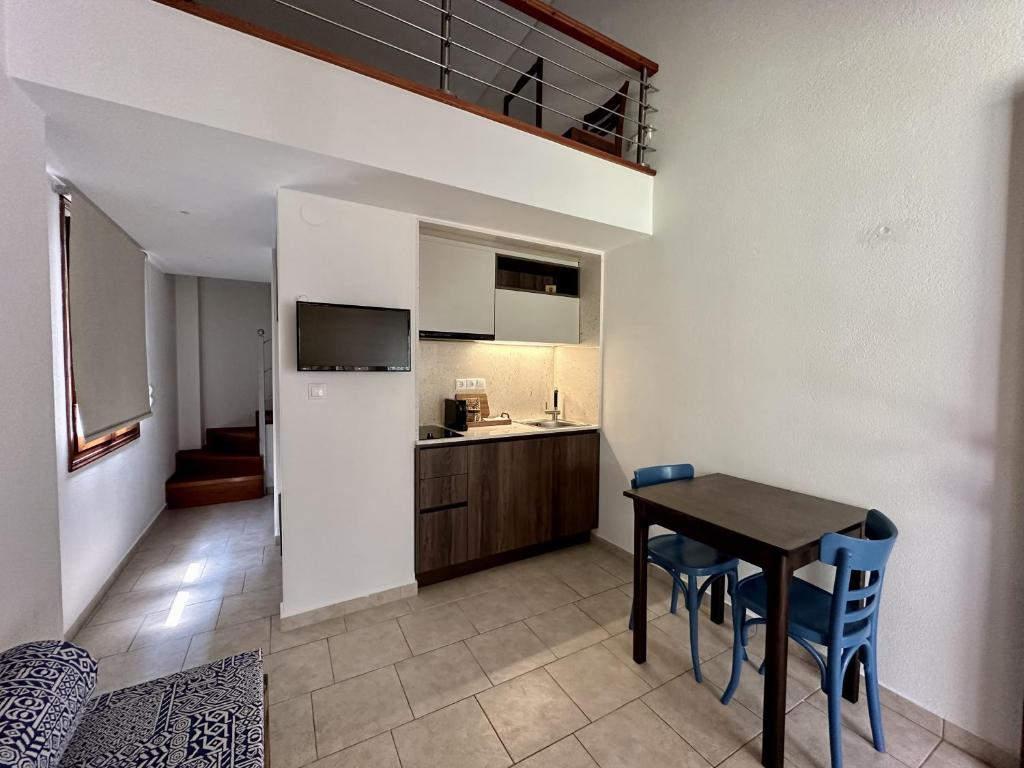 a kitchen and dining room with a table and chairs at Zouzoulas Filoxenia - Koralia Apartments in Mil&iacute;na