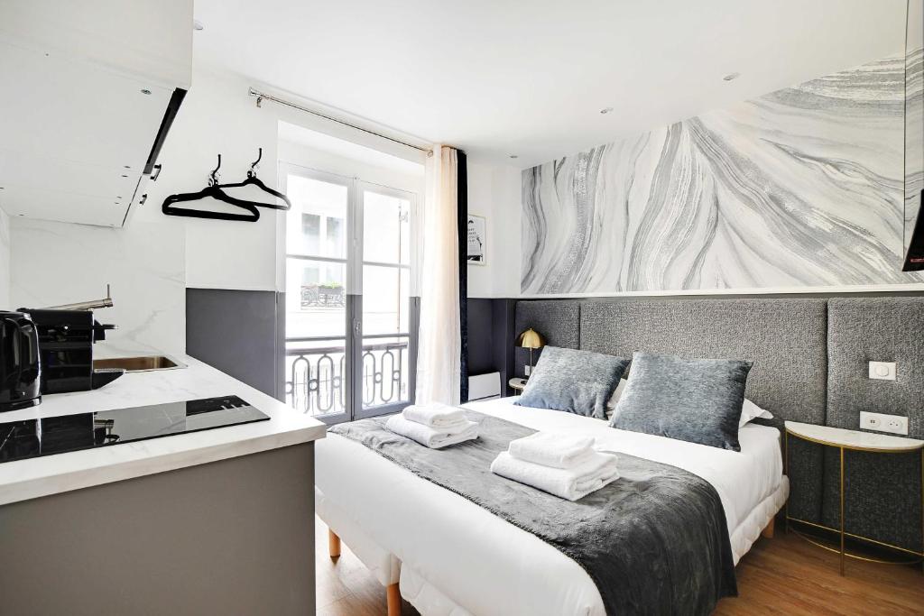 une chambre avec un grand lit et une cuisine dans l'établissement Modern Studio for 2P with A-C - Near Montmartre, à Paris