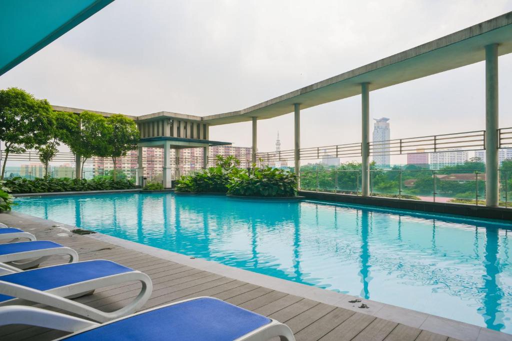 a swimming pool with lounge chairs on a building at Couple Suite at Casa Residency 5 mins walk to LRT, Jalan Alor & Bukit Bintang in Kuala Lumpur