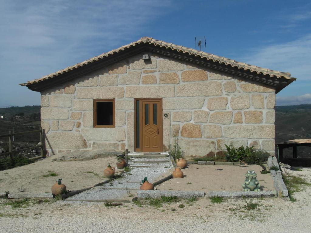 a small stone building with a door and some chickens outside at Casa da Bôcha in Cativelos