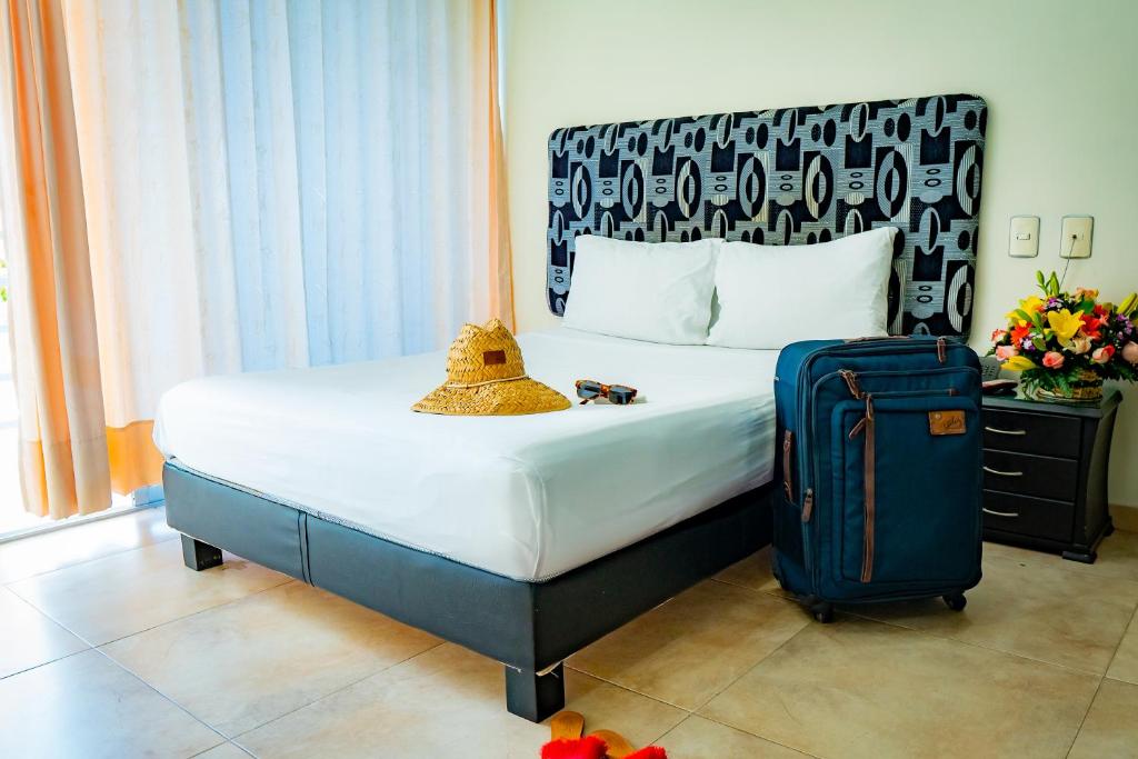 a hotel room with a bed and a suitcase at KALINA HOTEL in Girardot
