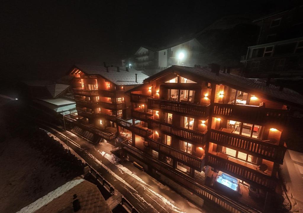 a large building with lights on it at night at La Cresta Chalet in Breuil-Cervinia