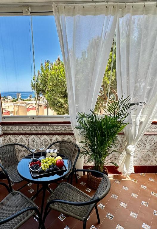 a table with a bowl of fruit in front of a window at Budget-Apart Caronte in Riviera del Sol, Mijas Costa in Mijas Costa