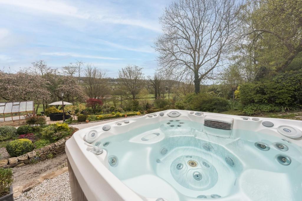 a jacuzzi tub in a garden at Oker Farm - Luxury farmhouse with hot tub in the Peak District in Matlock