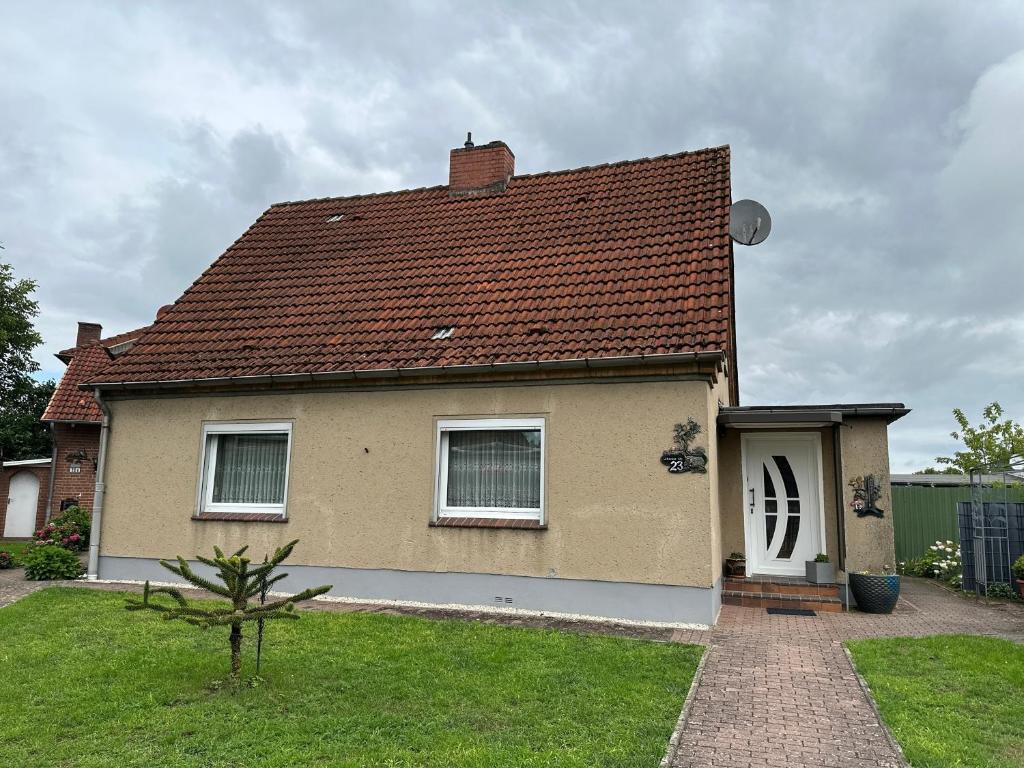 a house with a brown roof and a grass yard at Ferienhaus in Grevesmühlen