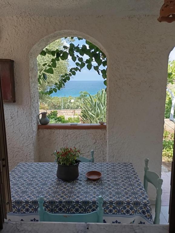 a table in a room with a view of the ocean at La casita in Capo Vaticano
