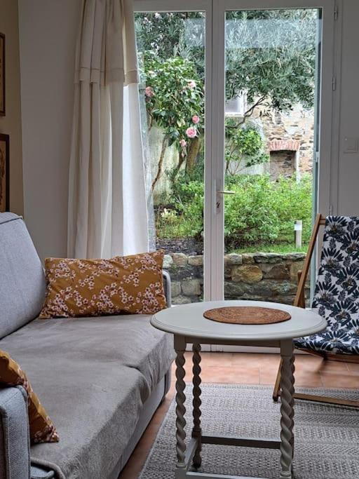un salon avec un canapé et une table dans l'établissement Maisonnette l'Olivier Bleu, à Nantes