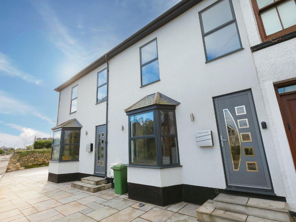 een wit gebouw met ramen aan de zijkant bij Avon Cottage in St Ives