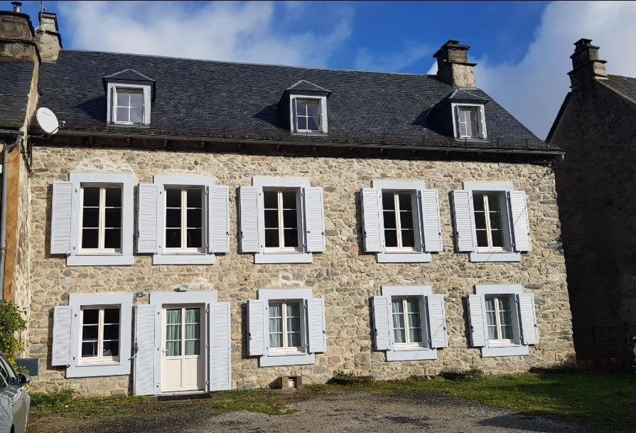 une ancienne maison en pierre avec des fenêtres blanches à volets dans l'établissement gentilhommière de Saint Amandin, à Saint-Amandin