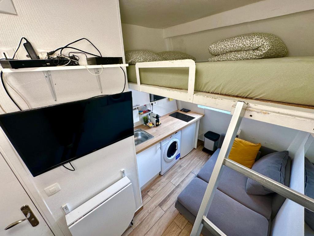 a small room with a bunk bed and a sink at Le Studio du Palais in Paris