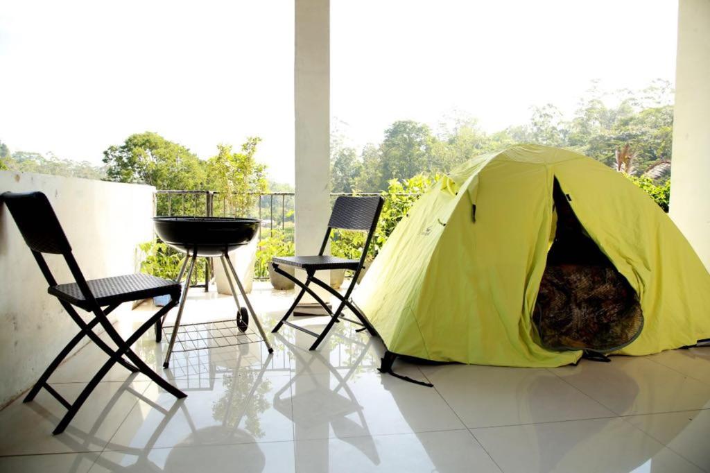 een gele tent met twee stoelen en een grill bij Hidden heaven holidays and camping organisers in Haputale