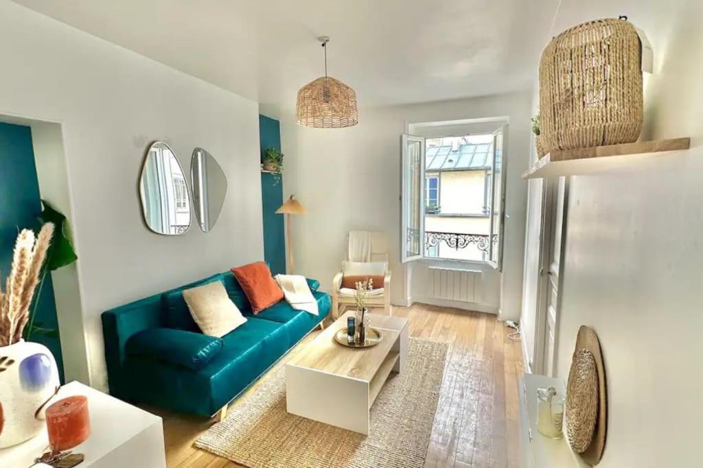 un salon avec un canapé bleu et une table dans l'établissement La perle Bleue - appartement cosy à La Défense, à Puteaux