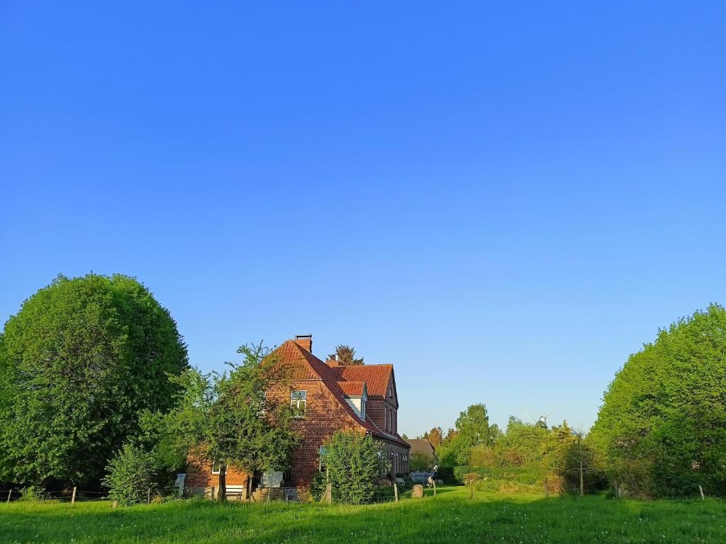 una casa vieja en un campo con árboles en Norby Garden Westwärts, en Rieseby