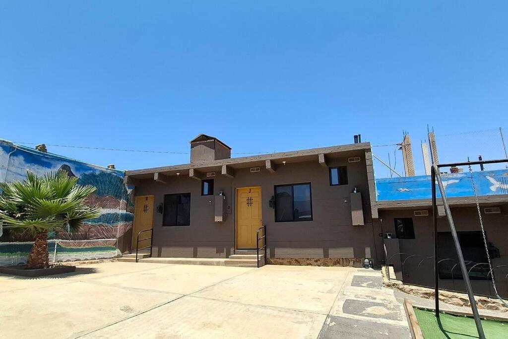 Un edificio con puertas amarillas y una palmera. en Oasis, en Buena Vista