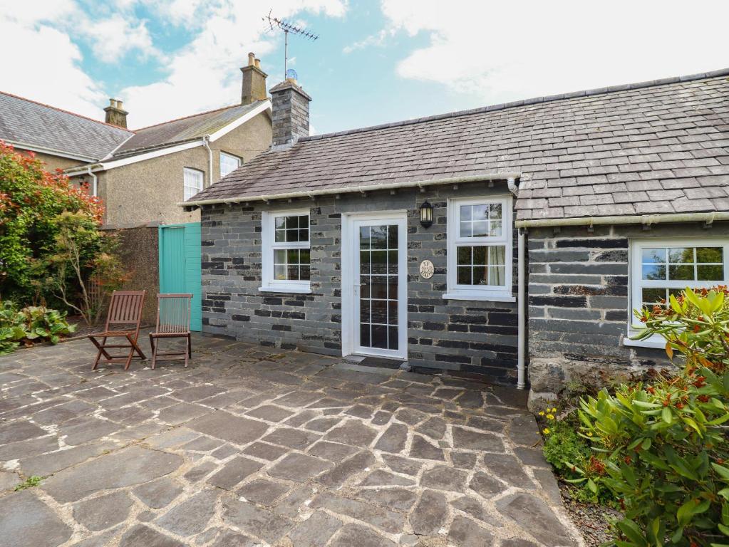 a stone patio in front of a house at Ty Llaeth Cottage in Tywyn