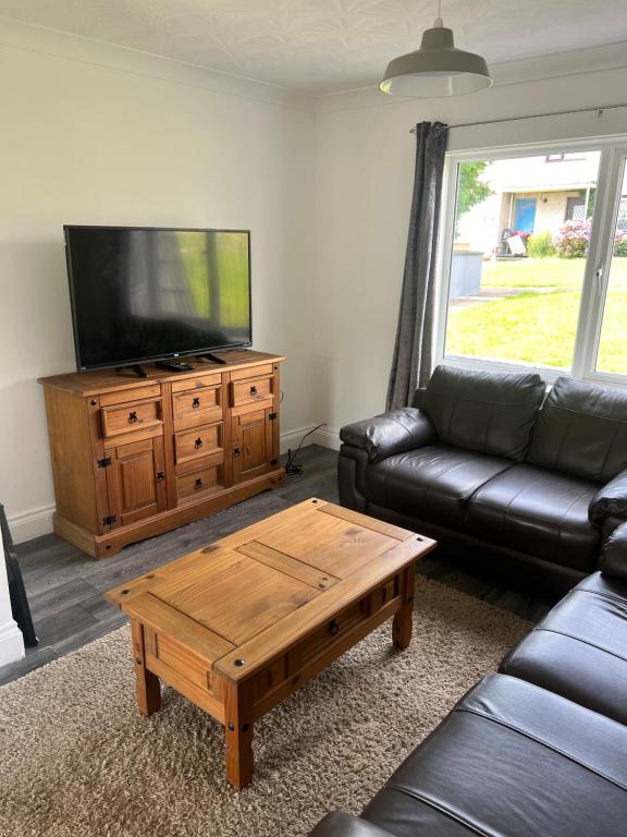 a living room with a couch and a coffee table at Cherry Blossom in Pembrokeshire