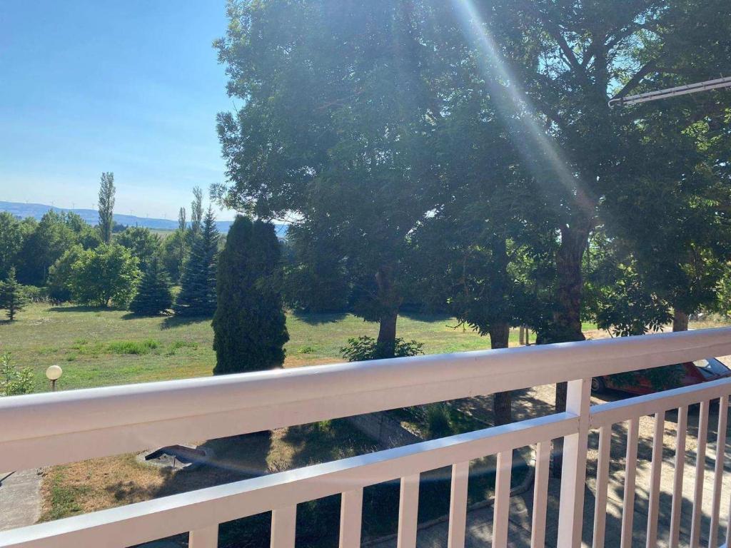 einen Balkon mit Blick auf ein Feld und Bäume in der Unterkunft Konak u Gradini in Tomislavgrad